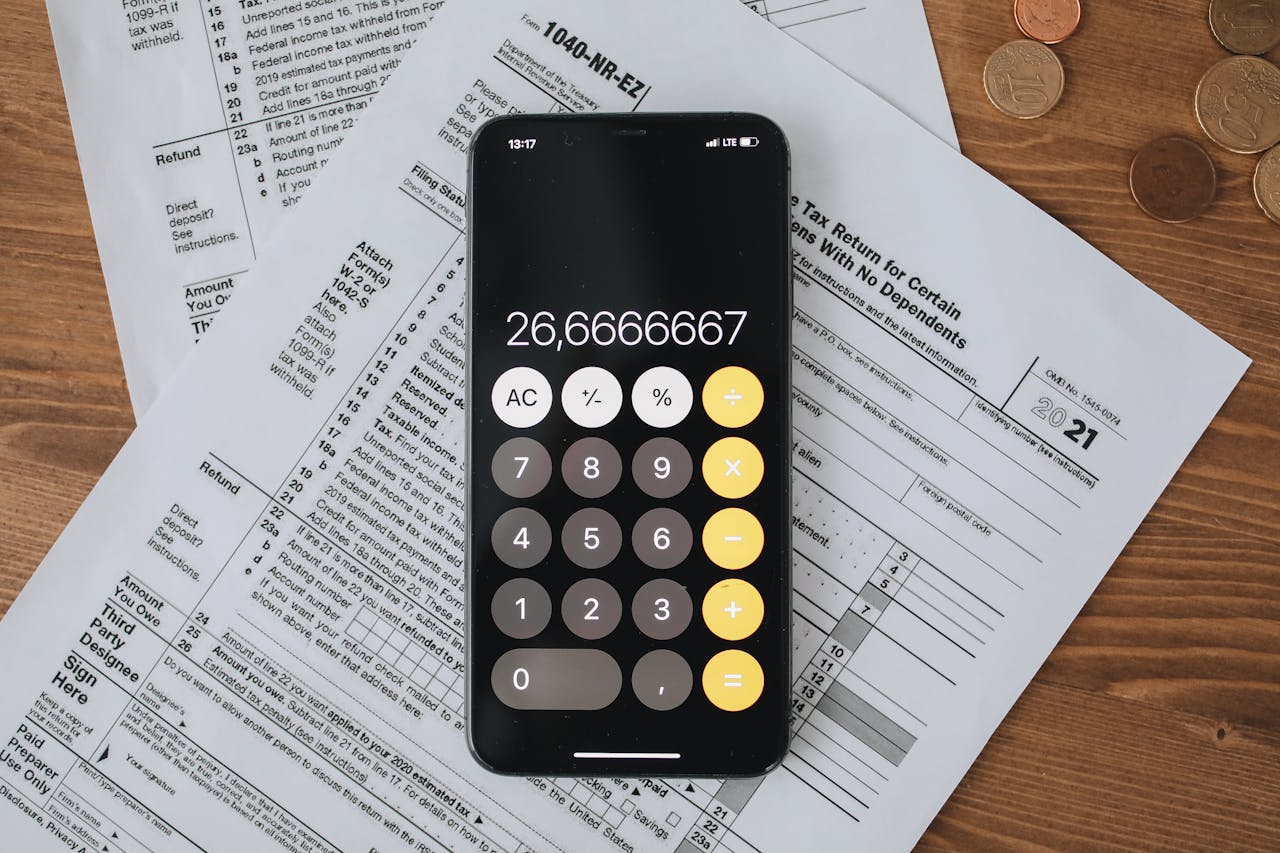 hero-img-01 Mobile calculator app on tax documents, highlighting financial calculations and tax preparation.